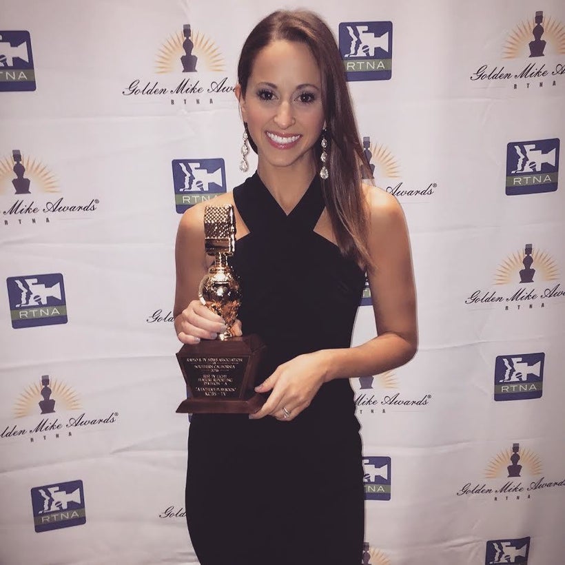 Holding her Golden Mike Awards trophy.