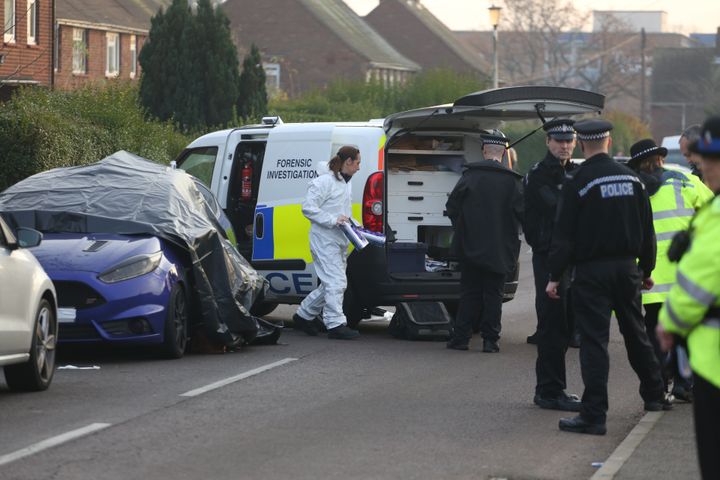 Forensics and police examine the car where the couple were found dead 