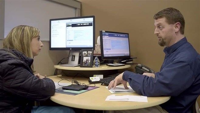 Tax preparer David Johns of H&R Block helps Allison Gersham on her taxes last month in St. Joseph, Missouri. State tax refunds can be delayed in at least 20 states, including Missouri, this year in an effort to combat fraud.