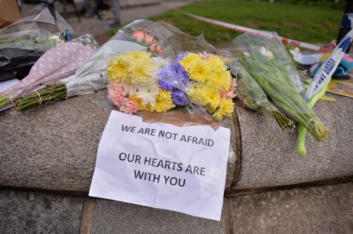 Floral tributes are seen near a police cordon in Westminster in central London a day after a deadly terror attack.