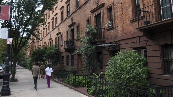 Trees line a quiet streetscape in the Harlem section of New York. Trees can help bring down rising temperatures in cities.