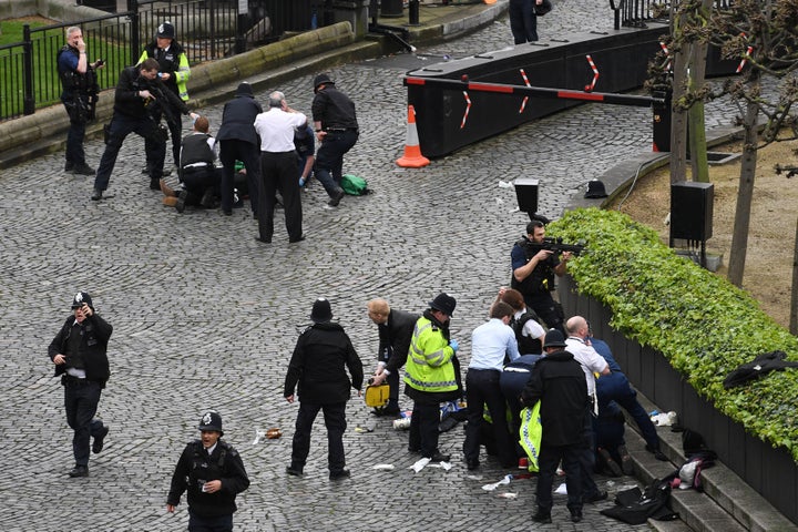 An officer points a gun at Masood, top left, following the stabbing of PC Palmer, bottom right