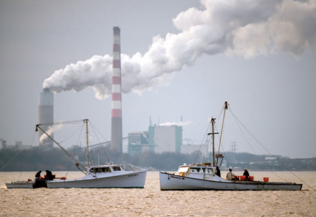 Two fishing boats anchored in front of a power plant on the Chesapeake Bay. Part of the federal cleanup effort in the region