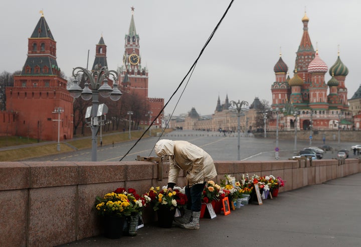 A woman adjusts flowers at the site of the 2015 assassination of Kremlin critic Boris Nemtsov in central Moscow on Monday.