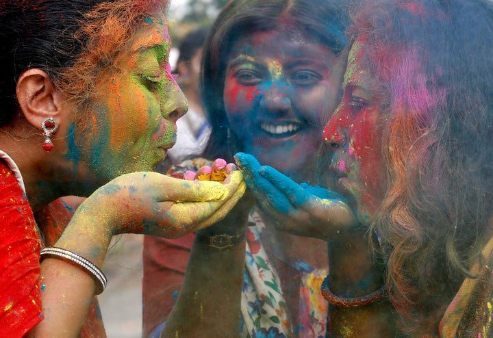 Students of Rabindra Bharati University blow colour powder during Holi, the Festival of Colours, celebrations inside the univ
