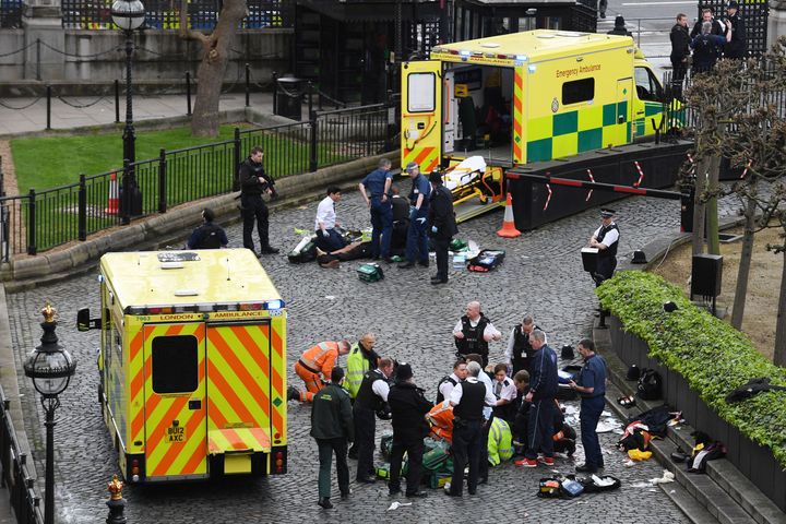 Emergency services attend a man (top) and a police officer (bottom) outside the Palace of Westminster on Wednesday