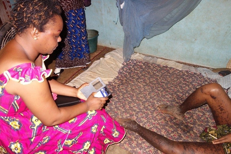 Isabelle using the CommCare application during her home visit with Aka.