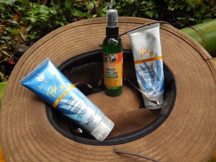 Rain forest essentials, safari hat with ventilation and a wide brim, bug spray, sun screen and water.