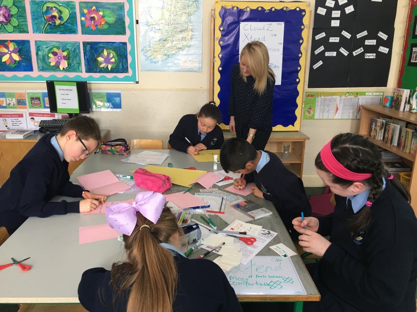 <em>Ms Mary Mackle, 5th Class Teacher watching the budding entrepreneurs at work.</em>