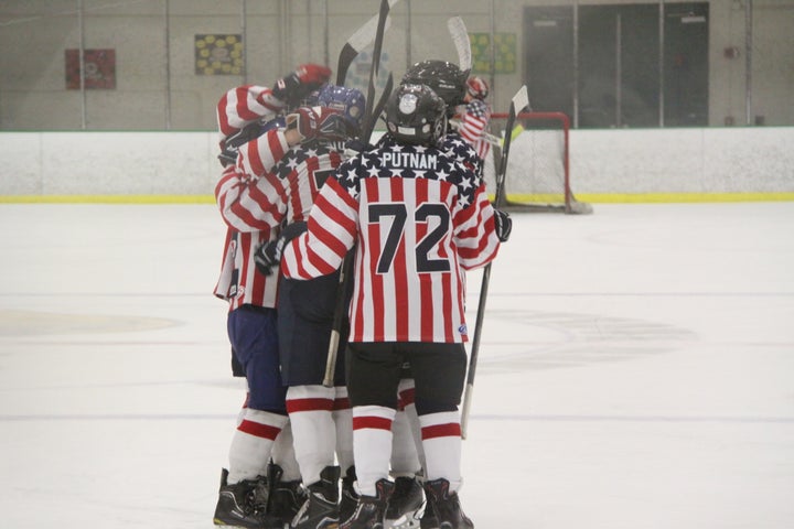 My son and his hockey teammates celebrate a goal.