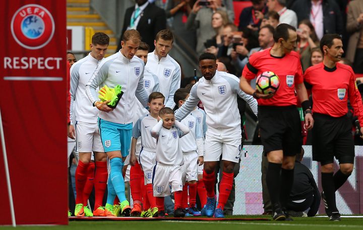 Bradley Lowery covers his ears as he walks out with Jermain Defoe at Wembley.