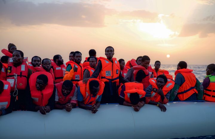 Migrants await rescue after receiving life jackets from the Minden aid ship 18 miles off the Libyan coast.