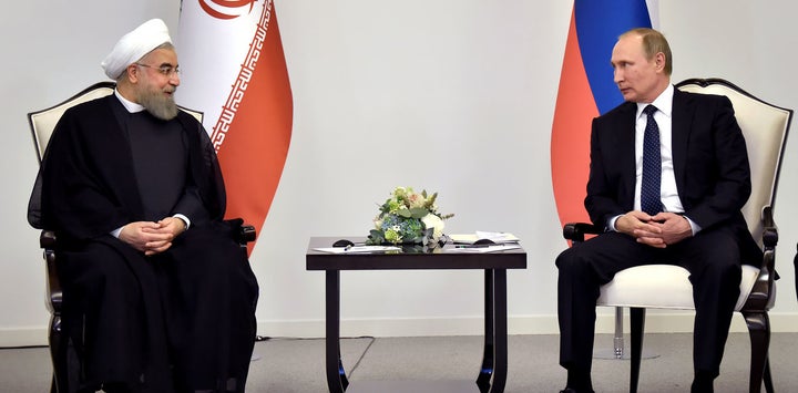 Iranian President Hassan Rouhani talks to Russian President Vladimir Putin during a meeting in Baku, Azerbaijan on August 8 2