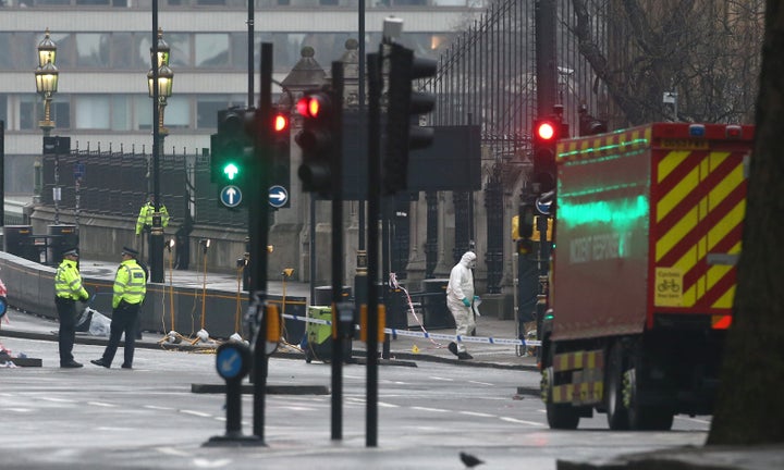 Forensics investigators and police officers work at the site near Westminster Bridge the morning after an attack by a man dri