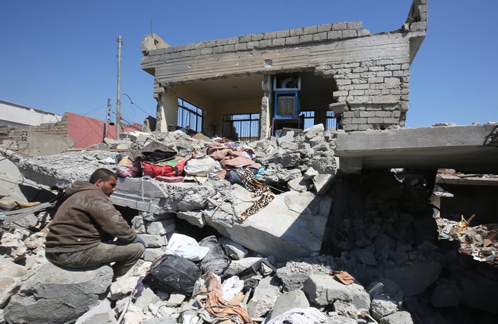 An Iraqi man sits amid the rubble of destroyed houses in the Mosul al-Jadida area on March 26, 2017, following air strikes in which civilians have been reportedly killed during an ongoing offensive against the Islamic State (IS) group.