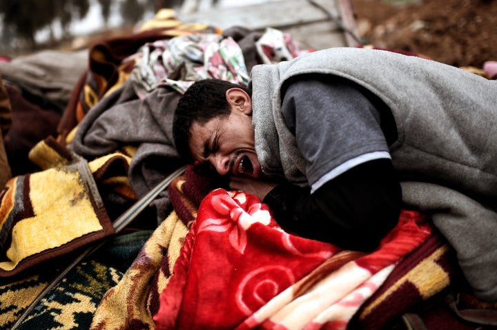 Relatives mourn as bodies of Iraqi residents of west Mosul killed in an airstrike targeting Islamic State (IS) group jihadists are placed and covered with blankets on carts on March 17, 2017.