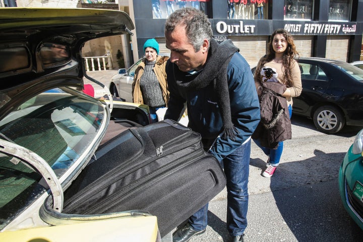 Faraj Ghazi al-Jamous, a Syrian refugee, loads his family's luggage into a taxi after departing from a hotel they had stayed in after they were prevented from travel to the United States in the Jordanian capital Amman on Feb. 1, 2017.