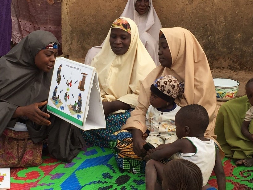 <em>A community volunteer in Nigeria discusses the introduction of complementary foods to children at six months of age.</em>