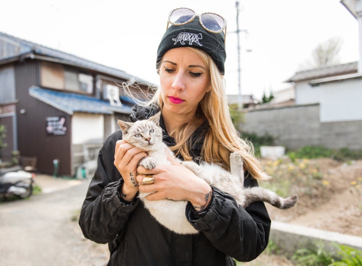 Cat rescuer and advocate Hannah Shaw holds a young cat on Ainoshima.