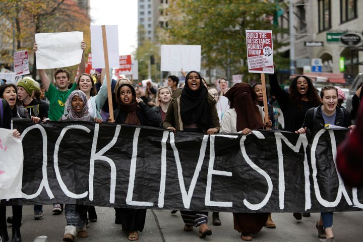 People carry a "Black Lives Matter" banner during a student walkout protest against Trump.