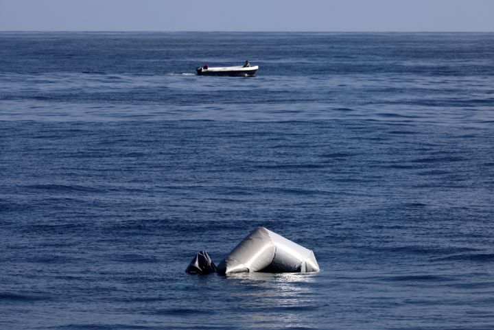 A Libyan fisherman speeds past the remains of a migrant raft in the central Mediterranean during a search and rescue operation by Spanish NGO Proactiva Open Arms on March 23, 2017.