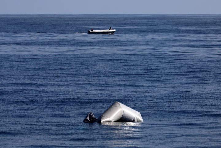 A Libyan fisherman speeds past the remains of a migrant raft in the central Mediterranean during a search and rescue operation by Spanish NGO Proactiva Open Arms on March 23, 2017.