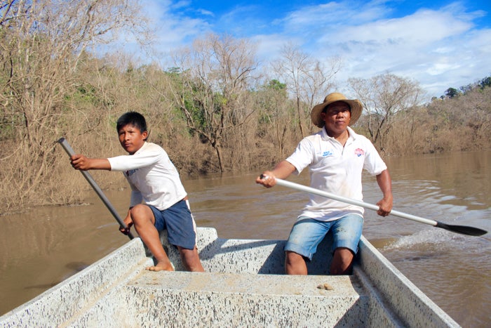 <em>Döegeo Gallardo and Göejet Miranda paddle home through the dead zone that was once a shady, fish-filled river. (Tracy L.