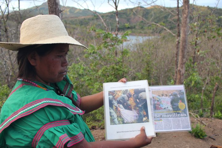 Clementina Pérez Jiménez, center, a leader of the Mama Tatda Church and of the September 22 Movement to stop the Barro Blanco dam, shows newspaper articles from the day she and others were dragged from their encampment by police and arrested. (Tracy L. Barnett)