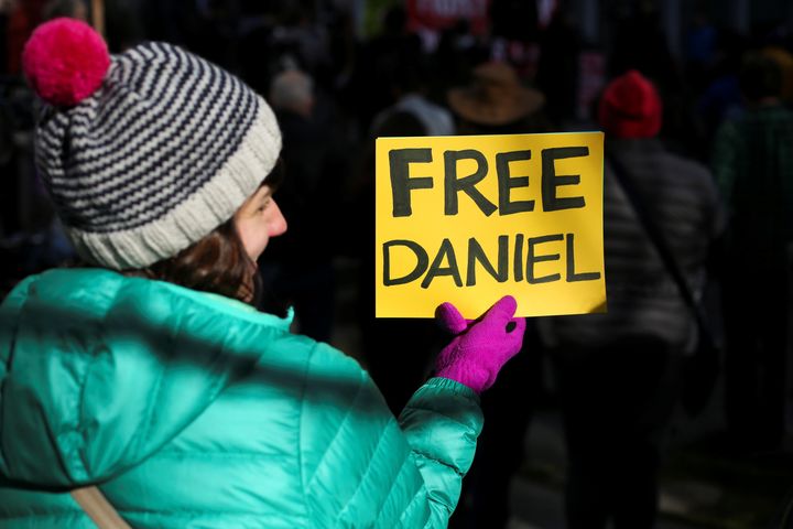 A woman holds a sign outside of the U.S. District Court during a rally in support of Daniel Ramirez Medina.