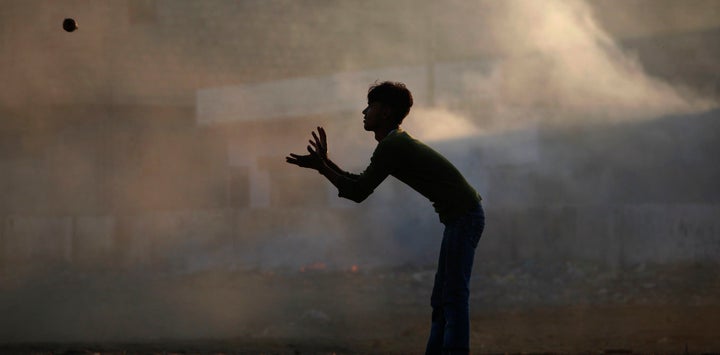 A boy silhouetted against smog while playing cricket in Karachi, Pakistan, in 2011.