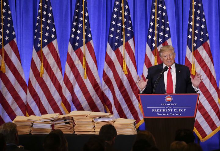 Trump speaks during his first news conference as president-elect in January, with props. 