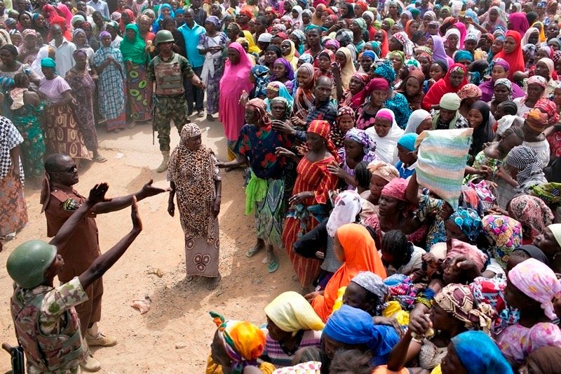 People in Michika, a town formerly occupied by Boko Haram, stand outside the gate waiting for food distribution on Feb. 20, 2
