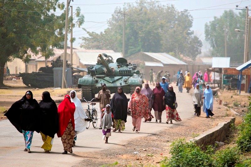 People walk towards the location of a food distribution in Michika, a town formerly occupied by Boko Haram, on Feb. 20, 2016.