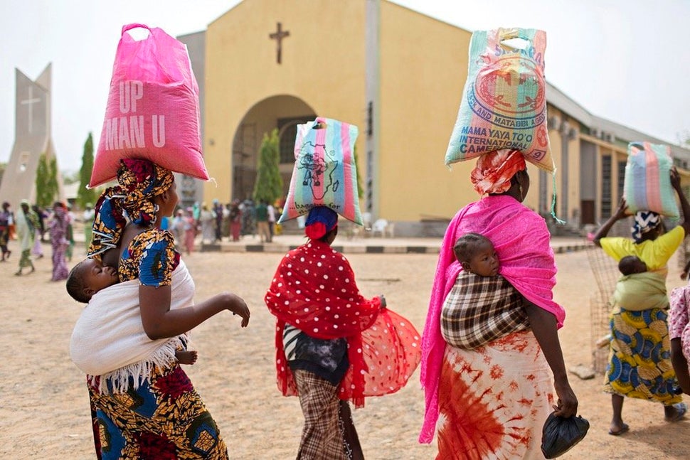 Women leave a food distribution hosted by St. Theresa’s Cathedral on March 21, 2016, in Yola, a city in northeastern Ni