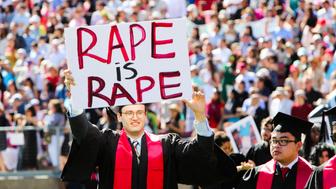 Stanford student Paul Harrison (C) carries a sign in a show of solidarity for a Stanford rape victim during graduation ceremonies at Stanford University, in Palo Alto, California, on June 12, 2016. 
Stanford students are protesting the universitys handling of rape cases alledging that the campus keeps secret the names of students found to be responsible for sexual assault and misconduct. / AFP / GABRIELLE LURIE        (Photo credit should read GABRIELLE LURIE/AFP/Getty Images)