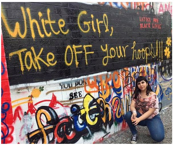 Alegria Martinez poses with graffiti.