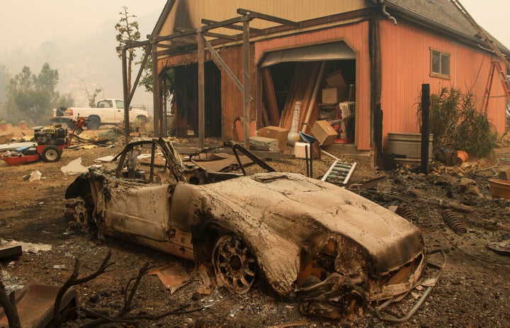 A burned out Porsche is seen near a partially burned home in the Santa Cruz Mountains near Loma Prieta, California on Septemb