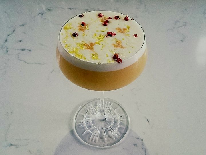 "The Duster" cocktail with Two James Johnny Smoking Gun Whiskey, Barrows Ginger Liquer, Yuzu Juice, New York Maple Syrup, Cherry Vanilla Bark Bitters, Egg white and garnished with pink peppercorn and Buddha hand zest.