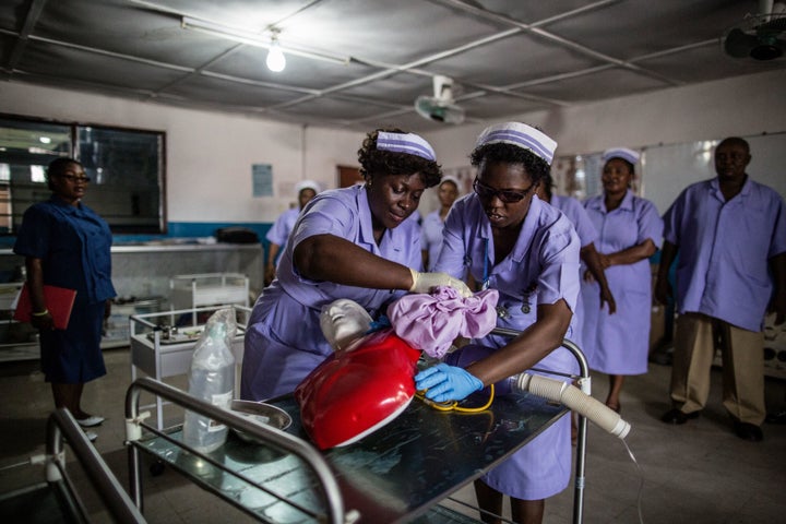 Students at the Masuba Midwifery School practice cardiopulmonary resuscitation on a dummy during a demonstration of their skills on April 26 in Masuba, central Sierra Leone. The United Nations Population Fund supports the local Ministry of Health with a program that promotes maternal health and family planning.