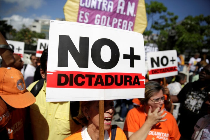 An opposition supporter holds a placard that reads "No more dictatorship" as she takes part in a rally against President Nicolas Maduro's government in Caracas, Venezuela on April 1, 2017.