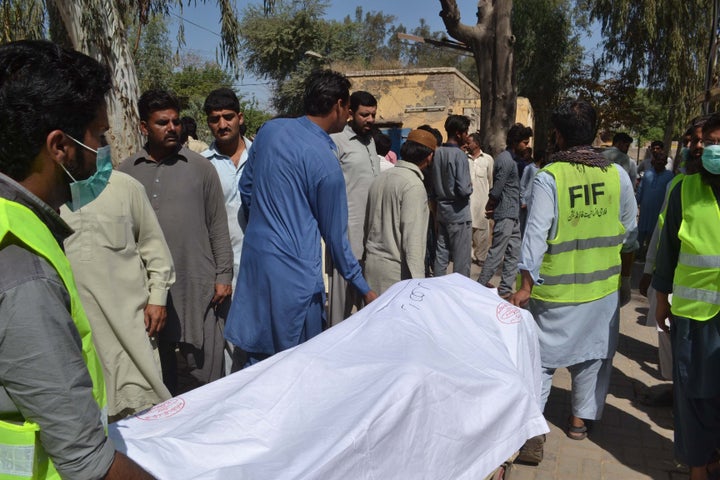 Pakistani emergency workers transport the body of a victim to hand over to their relatives at a hospital in the garrison city