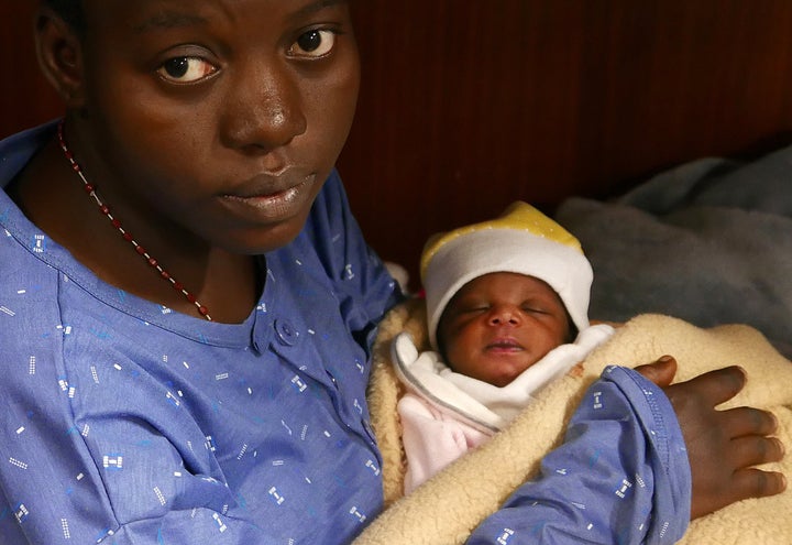 Mariam Ohene, a Nigerian migrant holds her baby girl aboard the former fishing trawler Golfo Azzurro, about thirty-two hours