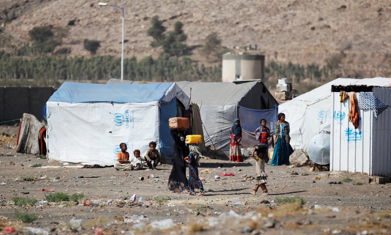 Girls carry cans filled with water at a camp for displaced Yemenis in Dharawan, near Sanaa, the capital of Yemen, on Feb. 28.