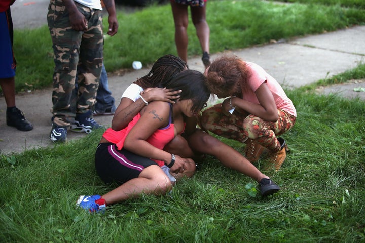 Friends gather and weep at the spot where a victim of a drive-by shooting died on June 22, 2013, in Chicago.