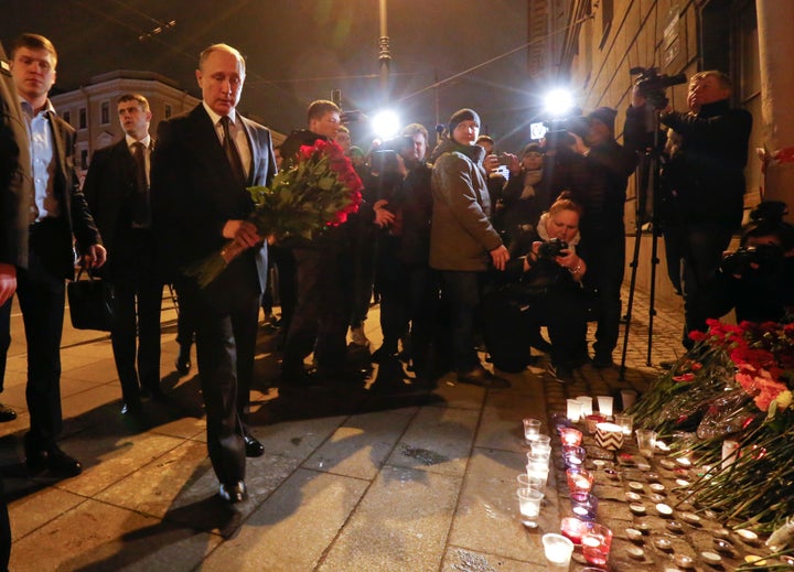 Russian president Vladimir Putin puts flowers down outside Tekhnologicheskiy Institut metro station in St Petersburg, Russia.