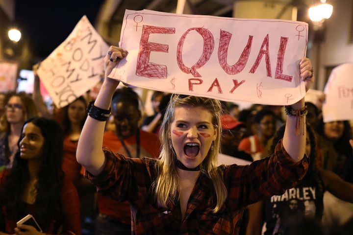 Clarissa Horsfall holds a sign for equal pay during a "Day Without A Woman" demonstration on March 8, 2017 in Miami.
