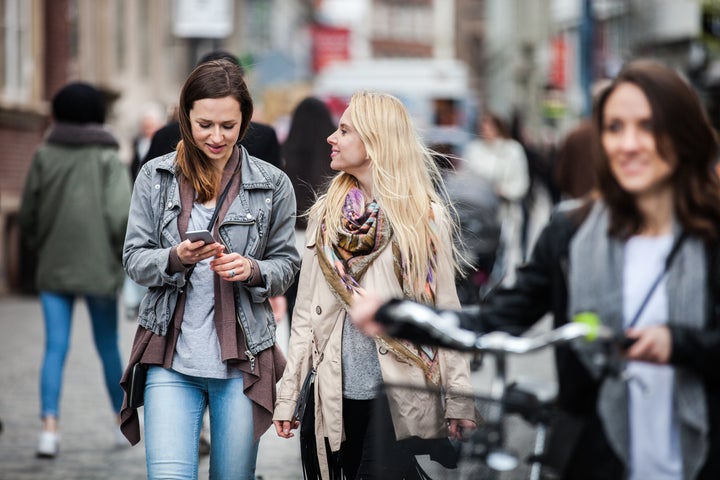 Three friends meetup in Copenhagen downtown during a beautiful spring day. LeoPatrizi via Getty Images