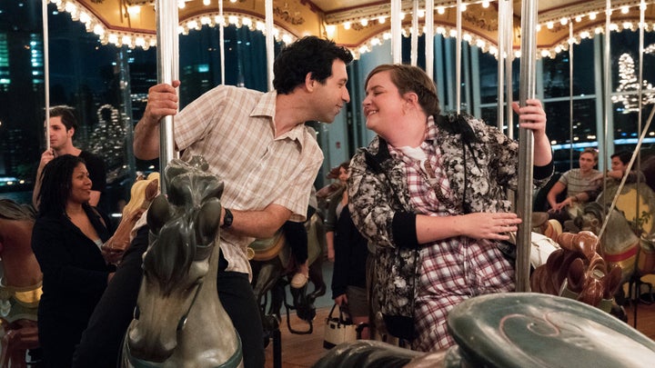 Ray and Abigail lean in for a kiss on the carousel on Brooklyn Bridge Park.