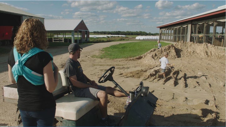 Allison and Dan Lauderdale watch two of their sons playing in the sand pile on the farm 