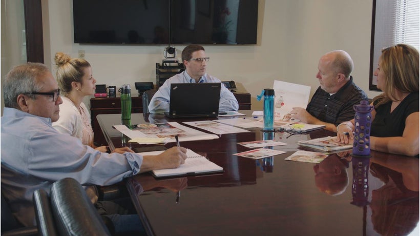 Bruce Bedford, VP of Analytics (center), leads a meeting with the Oberweis marketing team